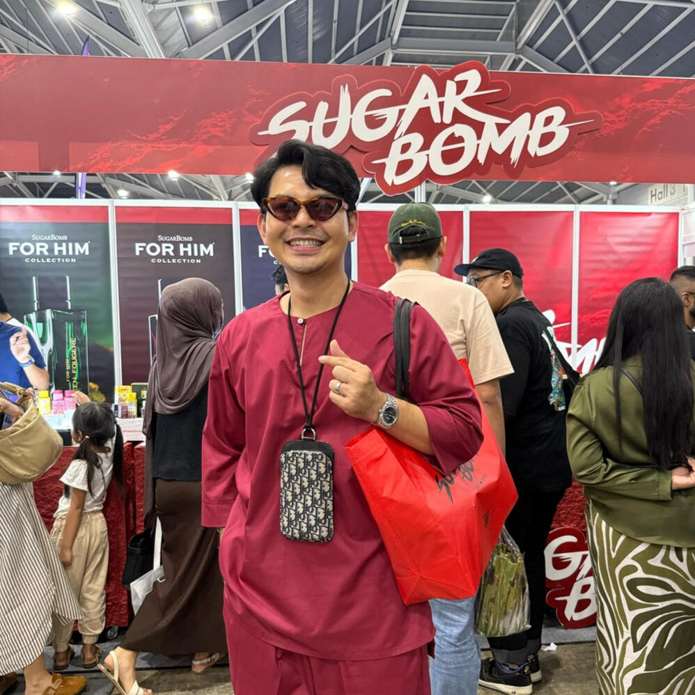Happy customers discovering their signature scents at our local popups. A customer holding a shopping bag at the SugarBomb SG display booth, voted a top affordable perfume store option in Singapore.